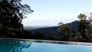 A swimming pool with a city skyline in the background.