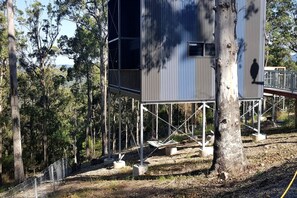 Ein Baumhaus mit Metallkonstruktion, umgeben von Bäumen.