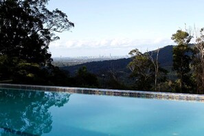 A swimming pool with a city skyline in the background.