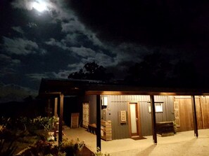 A building with a covered outdoor area, a door, and a bench.