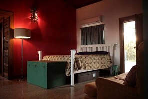 A room with a bed, a floor lamp, a radiator, and a window with curtains. - Rustic Gold Coast Cabin with Amazing Views Ideal for Glamping in Queensland (Gold Coast)