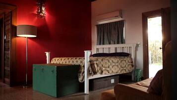 Een kamer met een bed, een vloerlamp, een radiator en een raam met gordijnen.