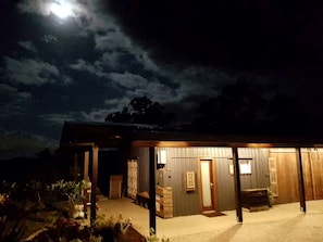 A building with a covered outdoor area, a door, and a bench.