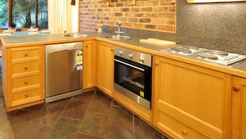 Una cocina con lavavajillas, horno y encimera de granito.