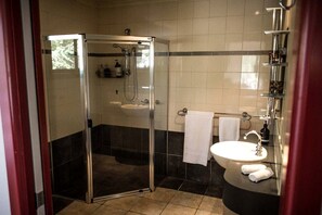 A bathroom with a glass-enclosed shower, a sink, and a mirror. - Marvelous Halls Gap Cabin Ideal for Romantic Getaways in Victoria (Halls Gap)