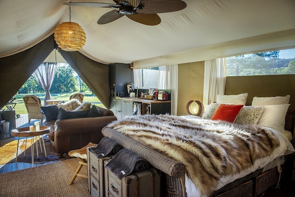 Un dormitorio con una cama grande, un escritorio y vistas al exterior.