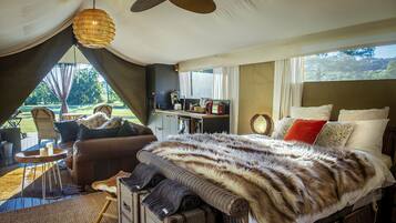 A bedroom with a large bed, a desk, and a view of the outdoors.