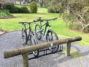 A bicycle rack with two bicycles parked on it.