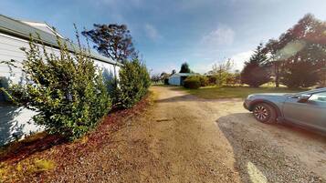 A gravel driveway leading to a house with a car parked on the right.
