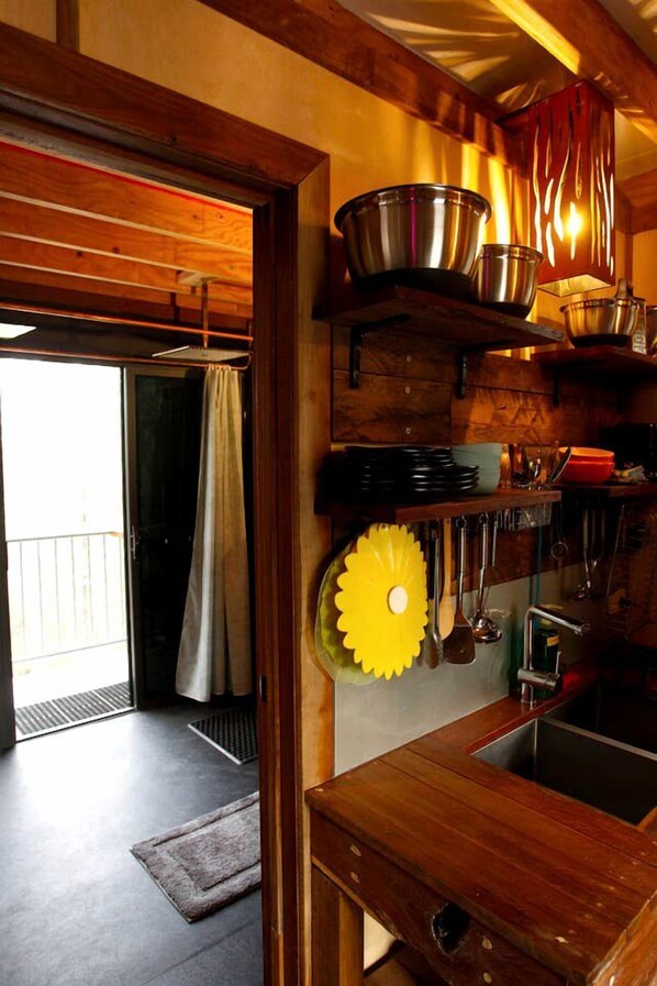 A kitchen with wooden cabinets, a sink, and various kitchen utensils.