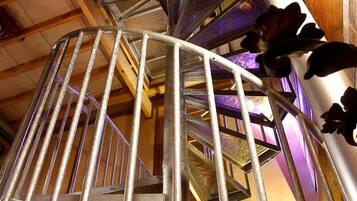 A spiral staircase with metal railings and a decorative ceiling fan.