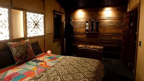 A cozy room with a bed, a bench, and a wooden wall with a mirror.