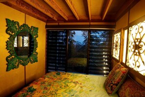 A bedroom with a bed, a mirror, and a window with blinds. - Amazing Gold Coast Tree House Perfect for Glamping in Queensland (Gold Coast)