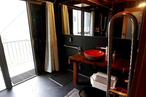 A bathroom with a red basin, a mirror, a shower, and a door leading to a balcony. - Amazing Gold Coast Tree House Perfect for Glamping in Queensland (Gold Coast)