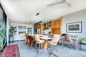 Una cocina moderna con armarios de madera, una isla central y taburetes de bar.