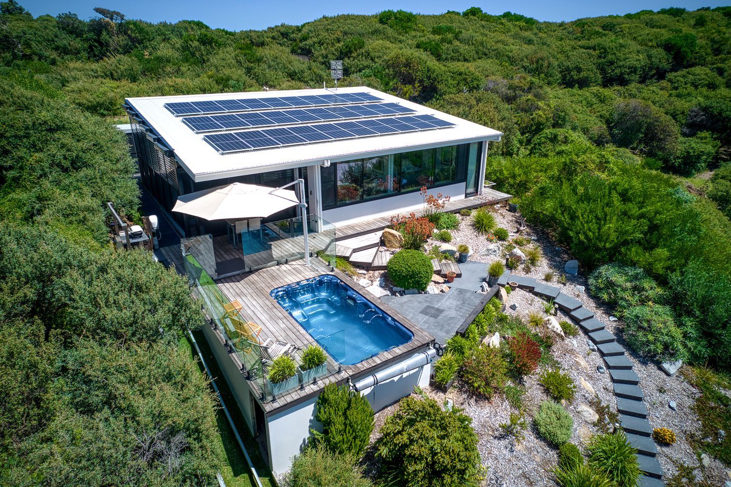 Ein modernes Haus mit Solardach, Schwimmbad und Garten.