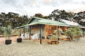 A rustic stone building with a covered patio and outdoor seating.