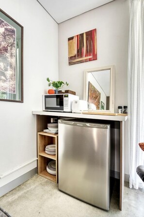 A compact kitchenette with a microwave, toaster, and small refrigerator.
