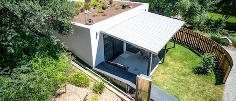 Una casa moderna con techo plano, terraza cubierta y jardín.