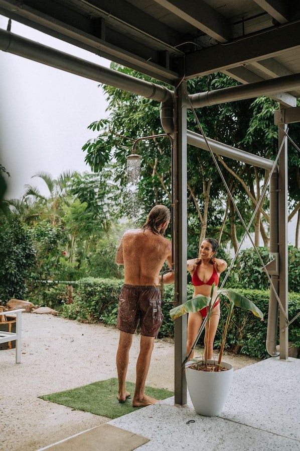 Un espacio al aire libre cubierto con una planta en maceta, una estructura metálica y un banco.