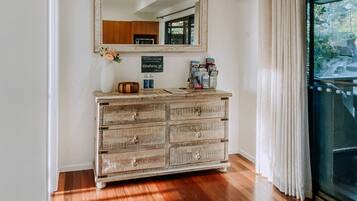 A wooden dresser with drawers, a mirror above it, and a sign with a website address.