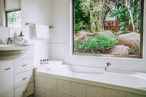 A bathroom with a bathtub, a sink, and a window with a view of rocks and greenery. - Secluded Mountain Cabin with Private Sauna & Ice-Bath Near Springbrook, Mudgeeraba, Queensland (Mudgeeraba)