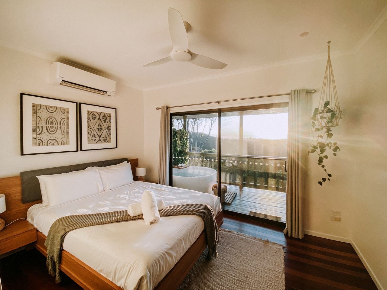 Une chambre dotée d’un grand lit, d’un ventilateur de plafond, d’un appareil de climatisation et d’un balcon avec vue.
