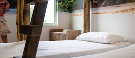 Ein Hotelzimmer mit Bett, Holz-Kopfteil, Fenster und einer Wand mit einem Wandgemälde zum Thema Natur.