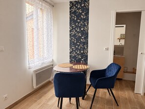 A room with a dining table and two chairs, a window with patterned curtains, and a vertical floral wallpaper. - L'Opaline - On the banks of the Seine near Giverny (Vernon)