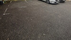 En flervåningsbyggnad med bostäder och en parkeringsplats.