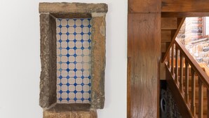 Una ventana enmarcada en piedra con un diseño geométrico azul y blanco.