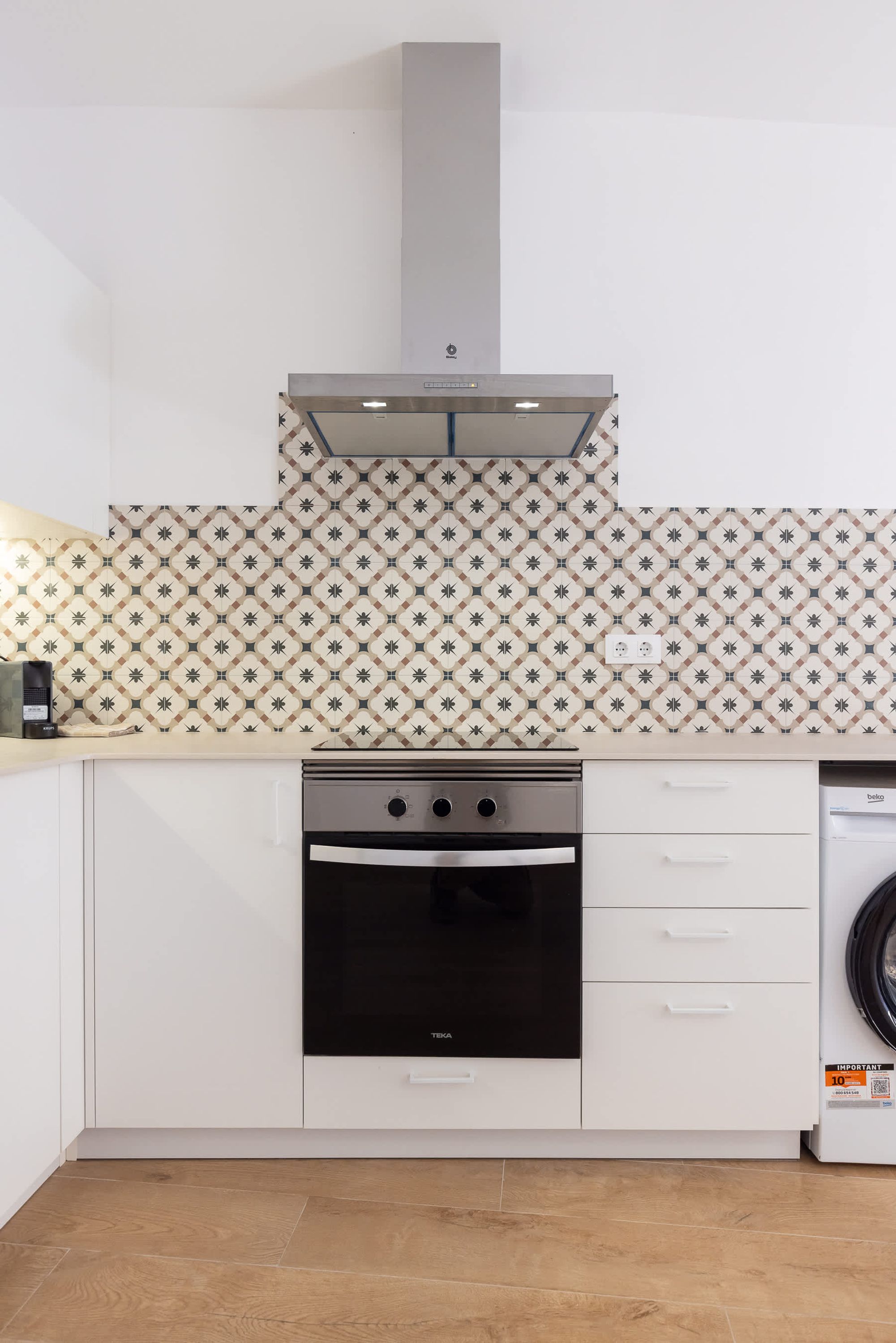 Una cocina con estufa, horno y lavadora.