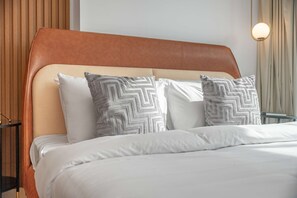 Ein Bett mit Kopfteil, Kissen und einem Nachttisch.