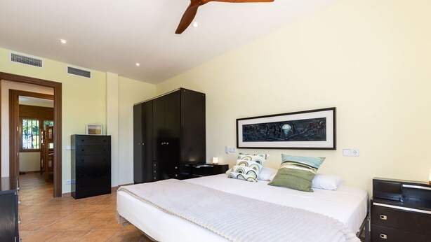 A bedroom with a large bed, a wardrobe, a desk, and a framed picture on the wall. - Masia Garriga in Tarragona (Alcover)