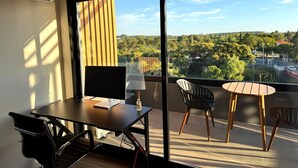 A modern room with a large window, a desk with a computer, a chair, and a small table. - Carmelo Postal in Carmelo (Carmelo)
