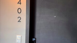 A door with a number '402' on the wall beside it, a light fixture above the door, and a door handle. - Carmelo Postal in Carmelo (Carmelo)