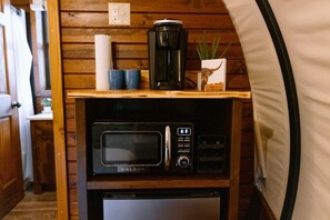 Zona de cuina compacta amb microones, cafetera i nevera petita.
