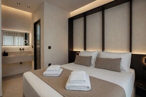 Ein modernes Hotelzimmer mit einem großen Bett, einem integrierten Schminktisch mit Spiegel und einem Nachttisch.