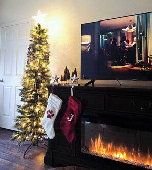 A Christmas tree with lights, stockings, and a fireplace with a TV on the mantel. - 2-bedroom townhome in St. Augustine (St. Augustine)
