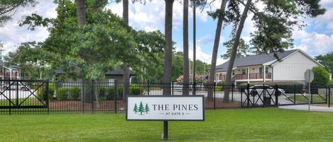 Un conjunto residencial cerrado llamado 'The Pines' con un letrero que indica 'En la puerta 5'.