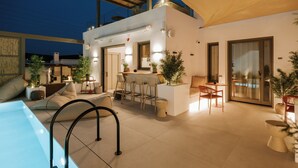 A modern outdoor living area with a pool, bar, and seating. - The Lofts Paros Executive Suites (Naousa)