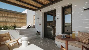 Un espacio moderno al aire libre con un muro blanco, techo de madera y vistas al paisaje.