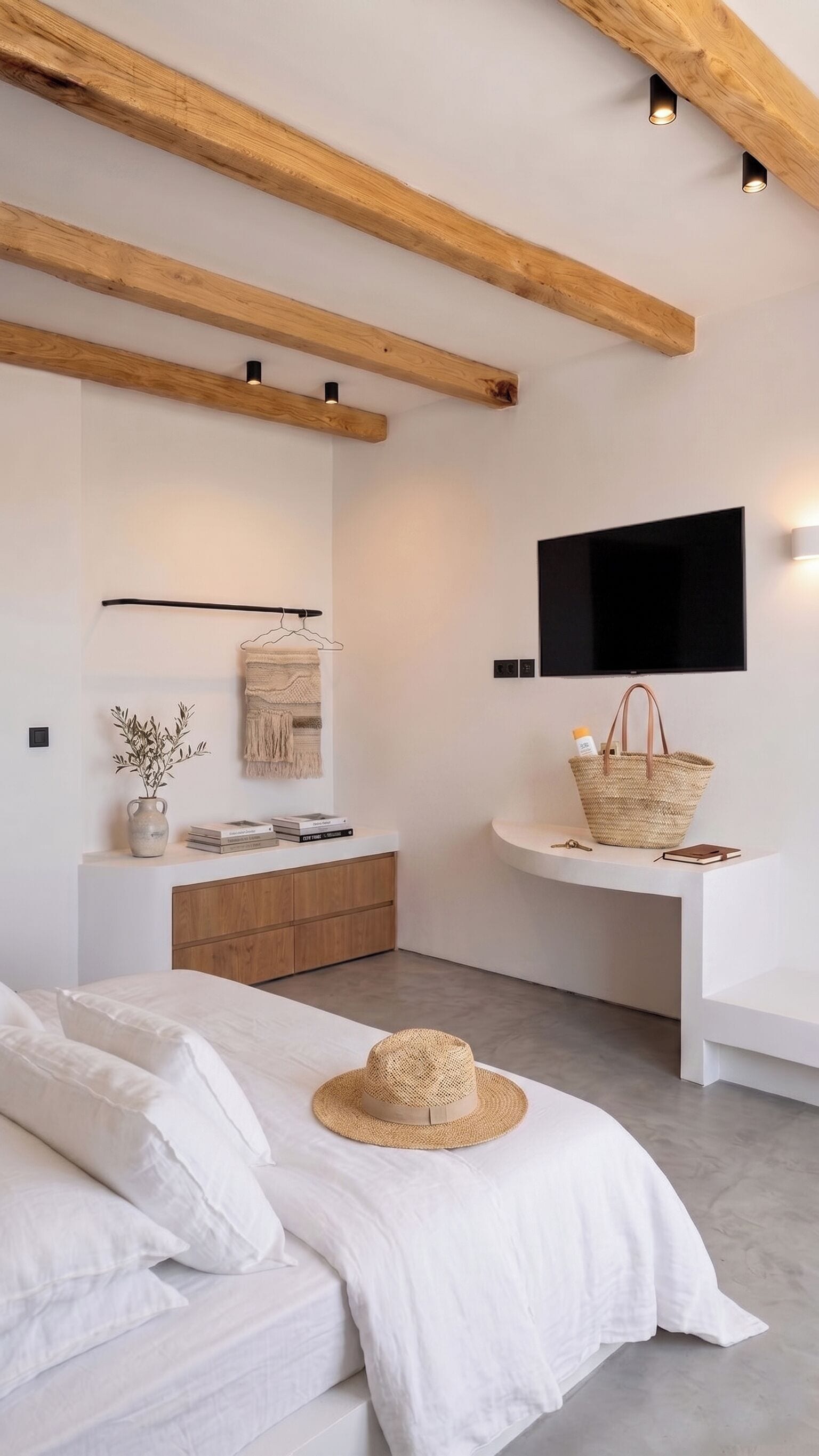 A modern bedroom with a bed, a bedside table with a basket, a mounted TV, and a wooden ceiling beam.