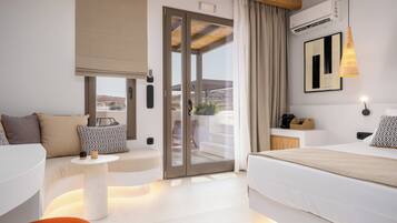 A modern hotel room with a balcony, a bed, a sofa, and a small table.