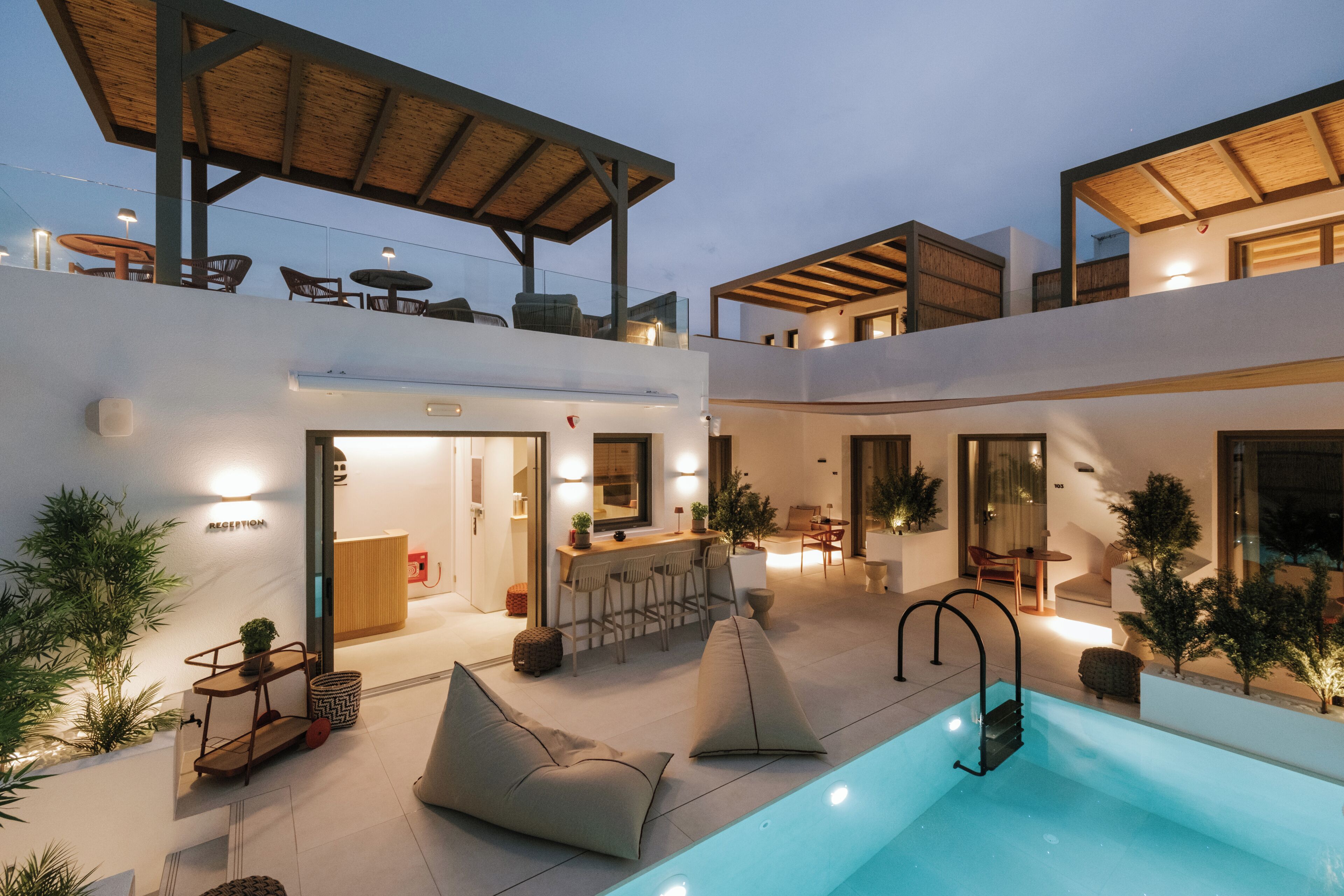 A modern outdoor pool area with a bar and seating.