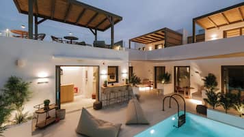 Un área de piscina moderna al aire libre con bar y asientos.
