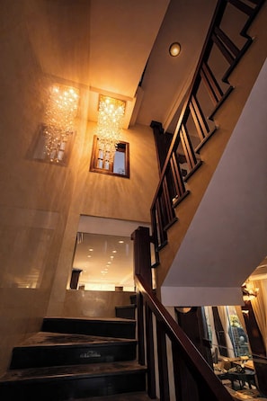 A staircase with wooden railings and a chandelier. - Mia Riverside Villa D7 with 9 bedrooms (Ho Chi Minh City)