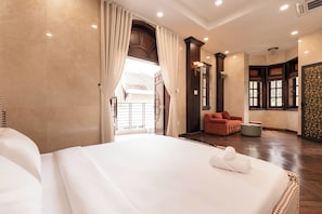 A hotel room with a large bed, a sitting area with a sofa, and a view of the outside. - Mia Riverside Villa D7 with 9 bedrooms (Ho Chi Minh City)