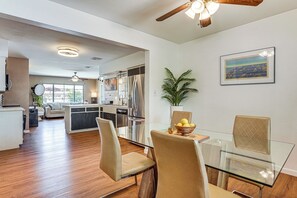 A modern kitchen with a dining area, wooden flooring, and a ceiling fan. - Picture-perfect Getaway w/ Remodeled Bath! (Scottsdale)