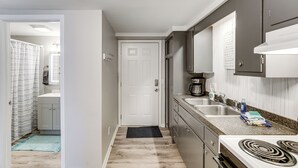 Una cocina con estufa, lavaplatos y armarios.